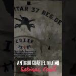 Pared oscura y deteriorada de un antiguo cuartel militar con pintura y logo de CRIIE, silueta de emblema y texto inferior que indica "ANTIGUO CUARTEL MILITAR Sabinas, Coah" y superposición que anuncia Desalojo inminente en Sabadell: 48 horas para dejar cuartel okupado.