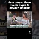 Reportera entrevista a un joven tatuado frente a un chalé con muro de piedra en Villaviciosa de Odón, Madrid, en una imagen con titulares que dicen "Este okupa tiene miedo a que le okupen la casa" y "Los okupas que se sienten propietarios" y el rótulo Chalé en venta con okupas por 107000 euros incluye desalojo como resumen informativo para accesibilidad y SEO.