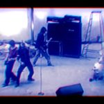 Banda de rock tocando en un local con amplificadores y batería, ambiente de ensayo — Propietaria okupas su casa y realiza huelga de hambre