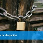 Puerta de madera cerrada con una cadena metálica y un candado, simbolizando el problema de la ocupación en España, donde las Viviendas de lujo vacías, objetivo de mafias de okupación en España.