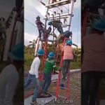 Operarios con cascos azules y arneses suben por escaleras apoyadas en una torre y manipulan líneas eléctricas junto a las vías en una escena de trabajo en altura que ilustra el Desalojo de jóvenes okupas en un edificio de Rekalde.